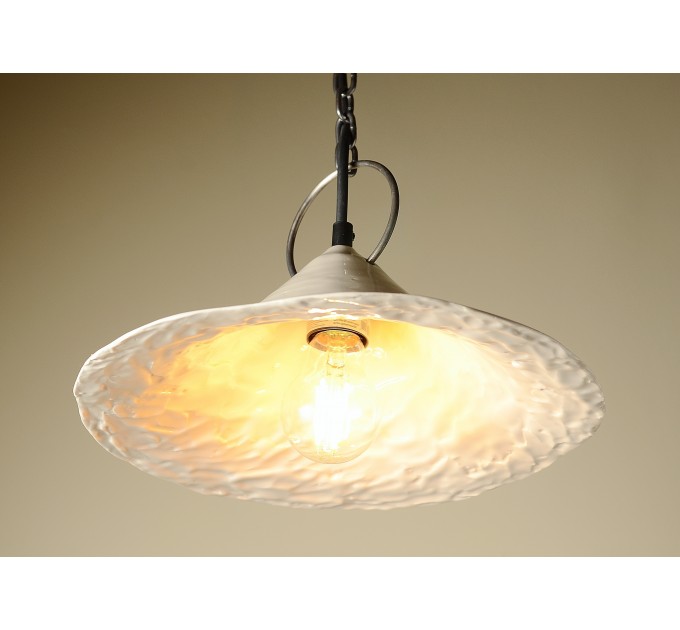 Handmade ceramic lamp in a rustic style hanging on a metal chain 