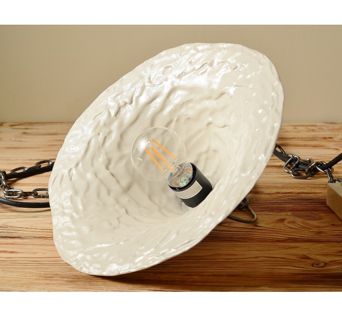Handmade ceramic lamp in a rustic style hanging on a metal chain 